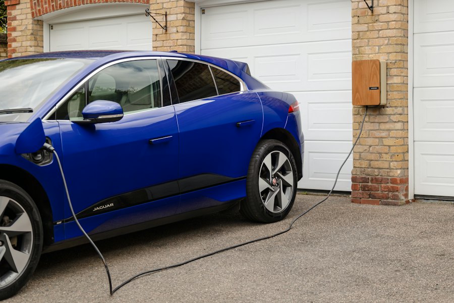 Electric car plugged into a charger outside a garage