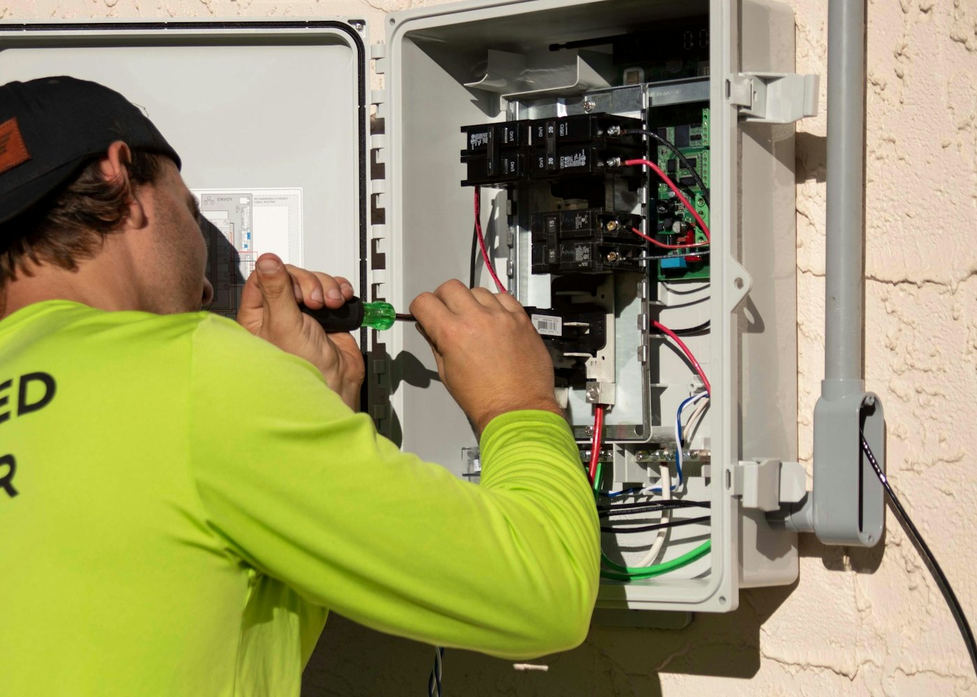 Electrician wiring breakers inside an open electrical panel