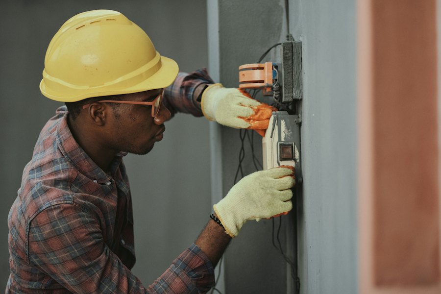 Electrician testing wiring at a wall-mounted box